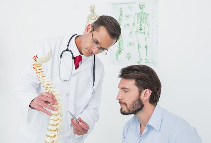 fpkdl.com_750_male-doctor-explaining-spine-patient_13339-269194